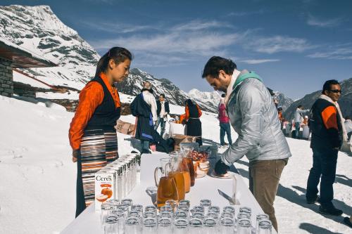 KongdeMountain Lodges of Nepal - Kongde的一群人站在雪地里的桌子旁