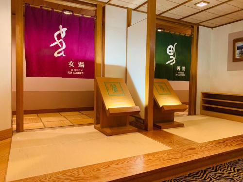 ŌyuRyumontei Chiba Ryokan的墙上有标牌的房间的两把长椅