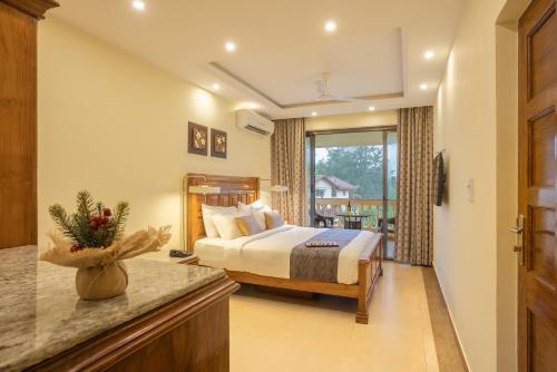 坎多林De Mandarin Beach Resort Suites & Villas, Candolim的酒店客房设有床和窗户。