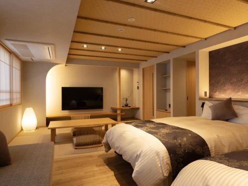 三好市卡祖拉巴希酒店的酒店客房设有两张床和一台平面电视。