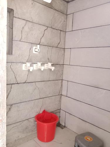 马图拉Hari Sharnam Home Stay的浴室里设有红色桶淋浴