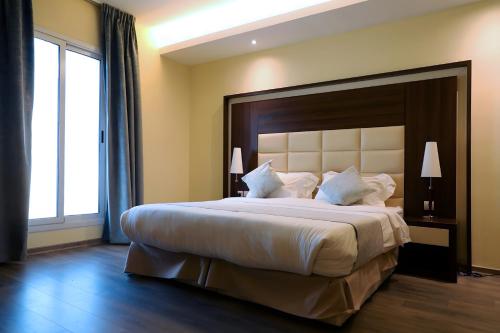 阿可贺巴Helat Hotel的一间卧室配有一张大床和大床头板