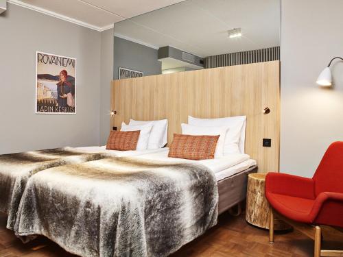罗瓦涅米罗凡涅米苏可酒店的酒店客房,配有一张床和一张红色椅子