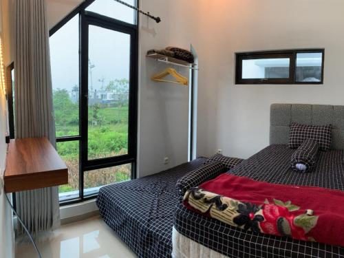 玛琅Villa Estetis di Kota Batu的一间卧室设有一张床和一个大窗户