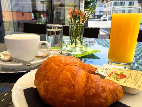 霍恩埃姆斯Hotel Café Schatz的桌上放有面包和橙汁的盘子