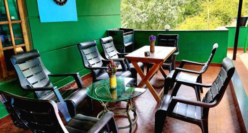 维特利pookode villa的一间设有椅子和桌子的房间,以及绿色的墙壁