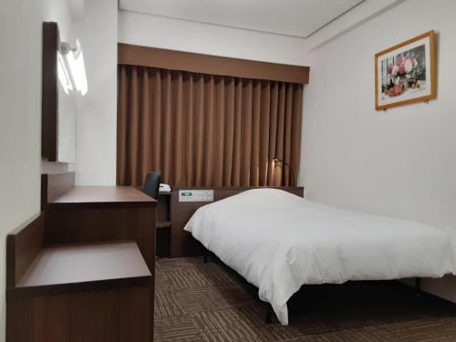 松江市Hotel Alpha-One Matsue的配有一张床和一张书桌的酒店客房