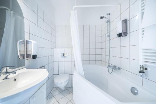 哈纳弗约德尔维京酒店的白色的浴室设有浴缸、卫生间和水槽。