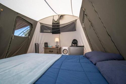 摩押Moab RV Resort Glamping Setup Tent in RV Park #2 OK-T2的帐篷内一间卧室,配有一张床