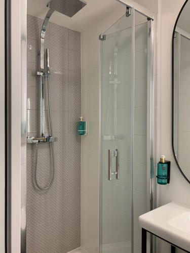 万塞讷Appart Hôtel Victoria的浴室里设有玻璃门淋浴