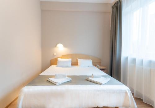 克莱佩达ARIBĖ Hotel Klaipėda, Free parking的一间卧室配有一张床,上面有两条毛巾