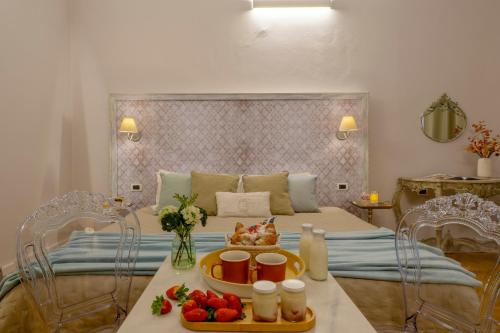普拉托阿坎托阿尔中心住宿加早餐旅馆的一间卧室配有一张带水果桌的床