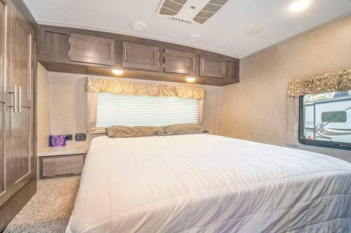 摩押Moab RV Resort Glamping RV Setup OK33的卧室配有一张位于走廊的大床