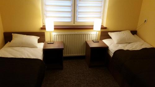 普鲁什库夫A2里克酒店的配有2张床的带窗户和2盏灯的客房