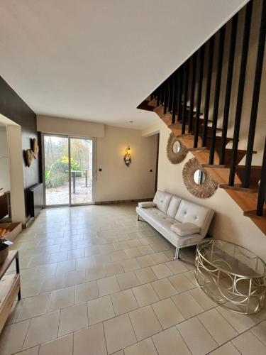 Saint-Germain-sur-BresleLa Lumineuse du Moulin的带沙发和楼梯的客厅