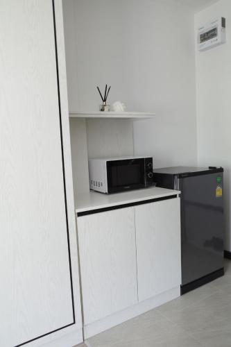 Ban PhalaVIYA Residence的厨房配有微波炉和冰箱。