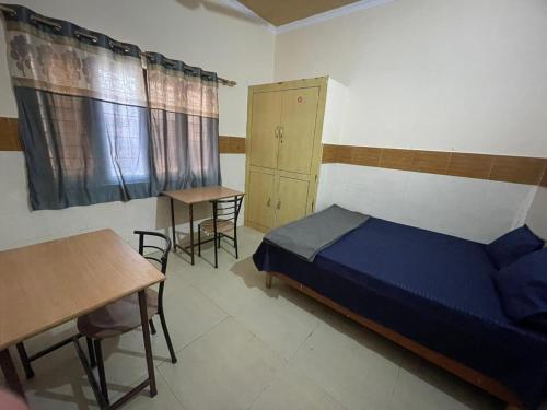 德拉敦Omjee Paying Guest的卧室配有一张床和一张桌子及椅子