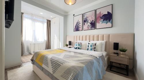 阿拉木图Уютная 2-комнатная квартира в центре г. Алматы的一间卧室设有一张大床和一个窗户。