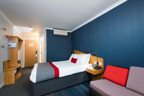 格拉斯哥快捷假日酒店 - 格拉斯哥 - 城市滨江CTR酒店的酒店客房,配有床和沙发