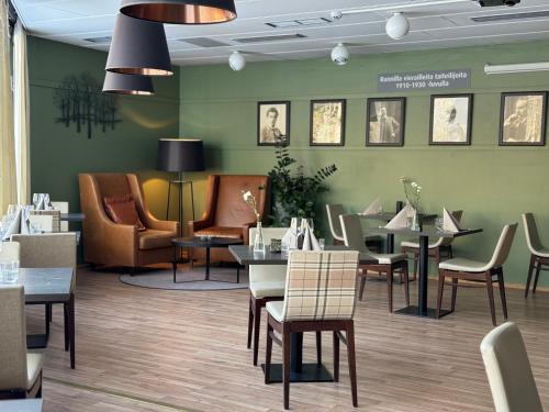 伊萨尔米Spa Hotel Runni Iisalmi的一间带桌椅和绿色墙壁的餐厅