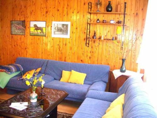 Ferienhaus Schöne的客厅配有蓝色的沙发和桌子