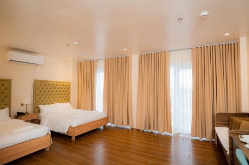 八打雁JVJ HOTELS CORPORATION的一间卧室设有两张床和大窗户