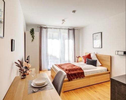 伊巴丹Spacious and Comfort Home的一间卧室配有一张床、一张桌子和一个窗户。