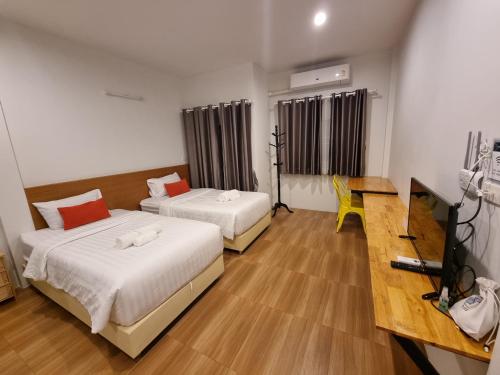 班杜Kandanai Place的酒店客房设有两张床和一张桌子。