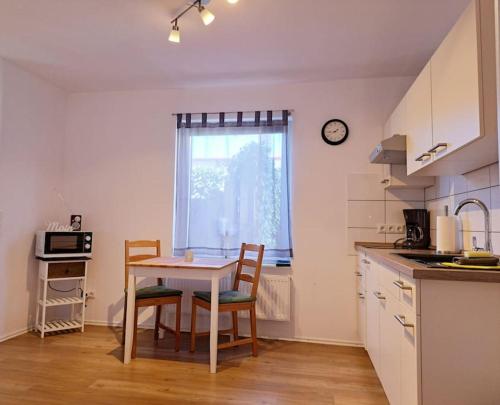 OesterdeichstrichSchönes 1-Zimmer-Appartement, Büsum (4km) Nordsee的厨房配有桌椅和窗户。