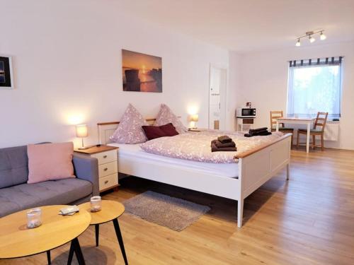 OesterdeichstrichSchönes 1-Zimmer-Appartement, Büsum (4km) Nordsee的一间卧室配有一张床、一张沙发和一张桌子