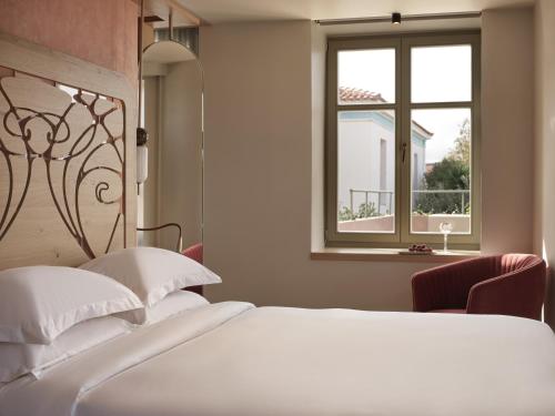 干尼亚Domus Blanc Boutique Hotel的卧室配有白色的床和窗户。