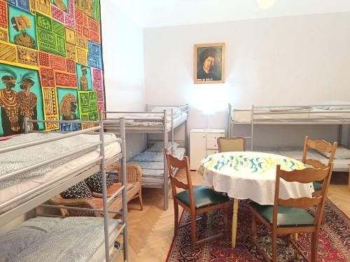 布达佩斯Babylon Hostel的客房设有双层床和桌椅。