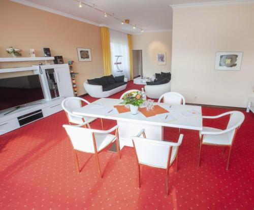维林根Hotel Hochsauerland 2010的客厅配有白色的桌子和椅子