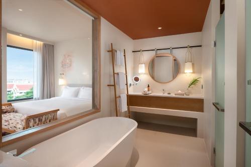 大城Centara Ayutthaya的带浴缸、床和镜子的浴室