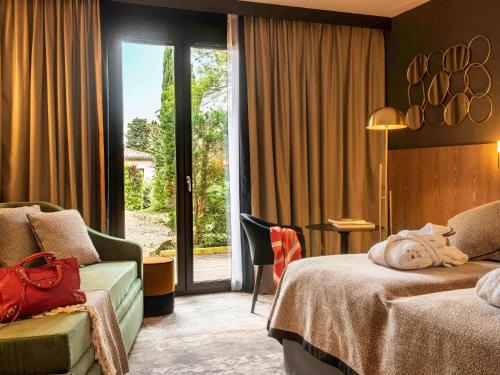 卡尔卡松Mercure Carcassonne La Cité的酒店客房,设有两张床和滑动玻璃门