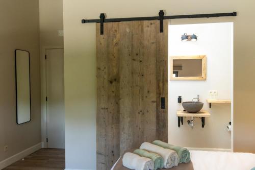 博尔赫隆B & B De Romeinse Katzei的浴室设有木制淋浴门和毛巾