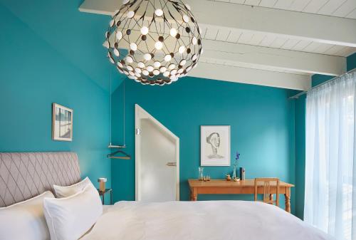 滕宁FriesThinkLand的一间蓝色卧室,配有一张床和一个吊灯