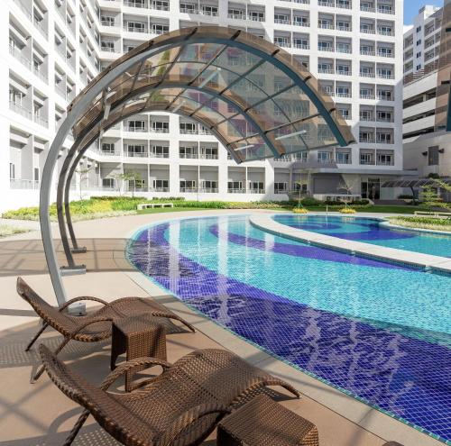 马尼拉SMDC GRACE RESIDENCE, TAGUIG (Near BGC, MCKINLEY,MAKATI)的大楼前的游泳池