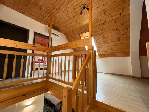 特尔日奇Holiday Home Planina的大客房设有木制天花板和楼梯。