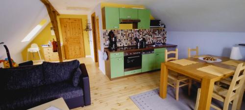 GotthunFerienhof Bauer的厨房配有绿色橱柜、桌子和沙发
