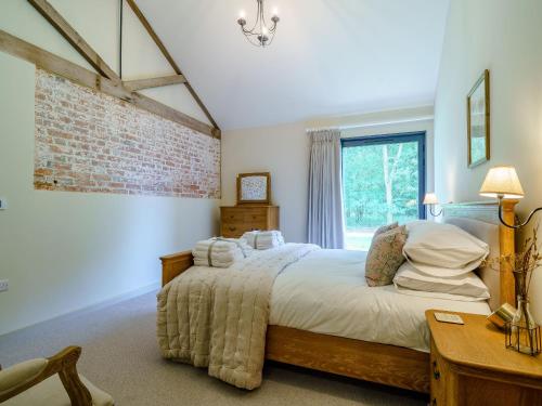东伊尔斯利2 Pheasant的一间卧室设有一张床和砖墙