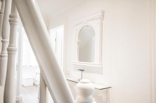 曼克玛肖Haus Twesk Merre的白色的走廊,设有镜子和楼梯