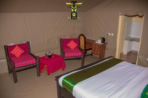 OlolaimutiekMara Olodare的一间卧室配有一张床、两把椅子和一张桌子