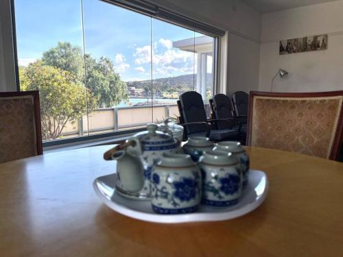 BelleriveBeach Cottage的一张桌子,盘子上放着四个蓝色和白色的罐子