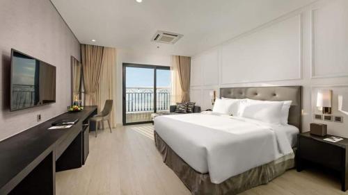 岘港GOLDEN APARTMENT With SEA VIEW的酒店客房设有一张大床和一张书桌。