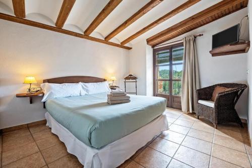 RojalsCal Tous, La Socarrimada的卧室配有床、椅子和窗户。