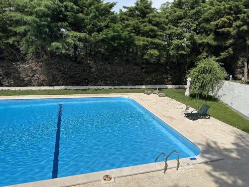 Pêro MonizQuinta dos Encantos "Entire Villa"的一座大游泳池,位于一个树木繁茂的庭院内