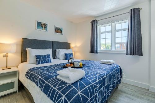 雷丁The Faculty by Celador Apartments的卧室配有蓝色和白色的床和窗户。