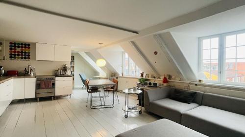 哥本哈根ApartmentInCopenhagen Apartment 1594的厨房以及带沙发和桌子的客厅。