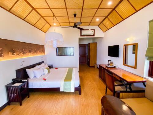 美奈翠竹村庄海滩水疗度假酒店的配有一张床和一张书桌的酒店客房